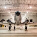 Front view of a vintage airplane in a well-lit hangar, showcasing aviation technology.
