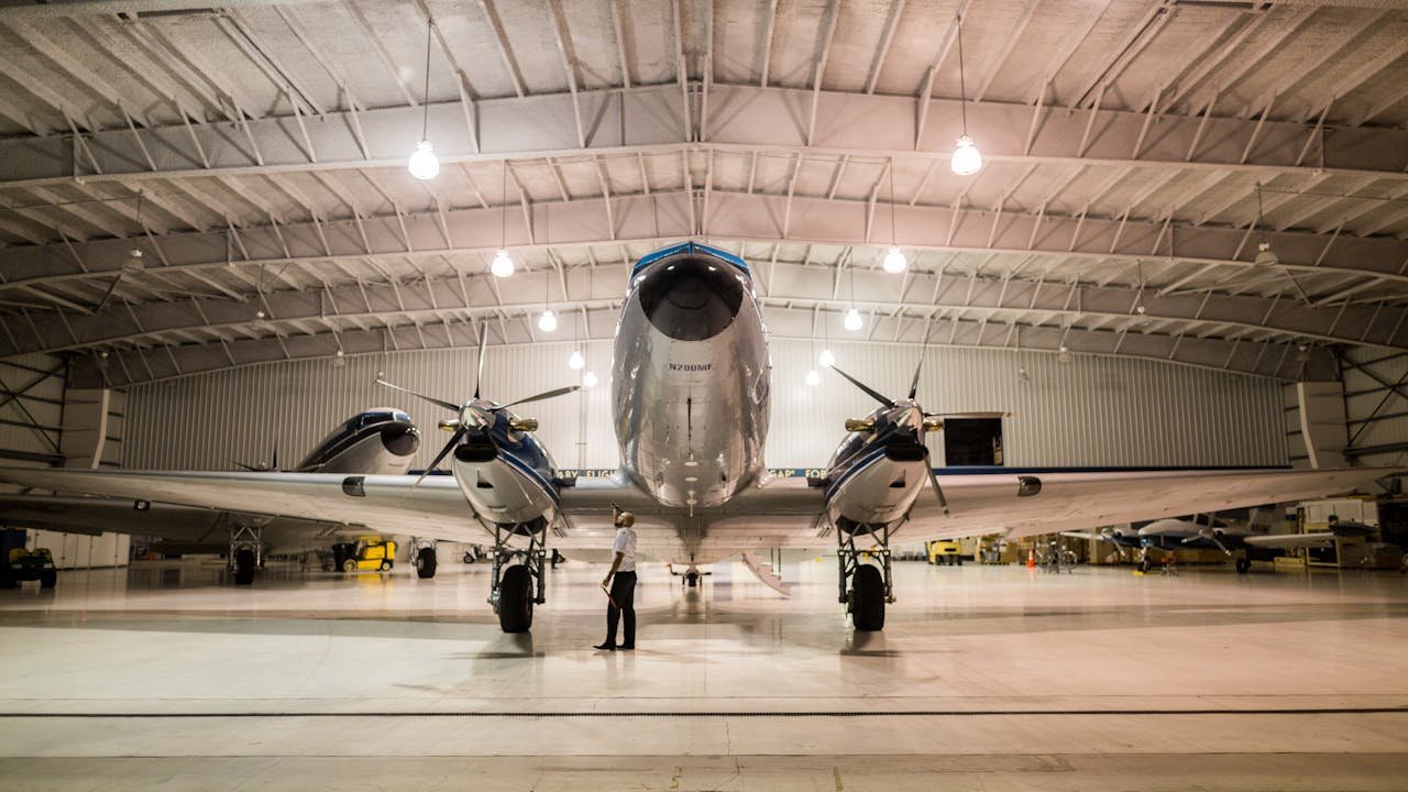 Front view of a vintage airplane in a well-lit hangar, showcasing aviation technology.